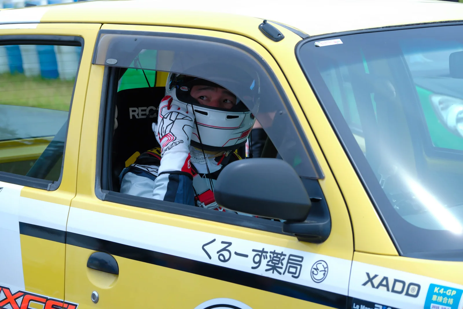 レーシングカーの運転席でヘルメットを着用した田畑誠（まこちん先生）